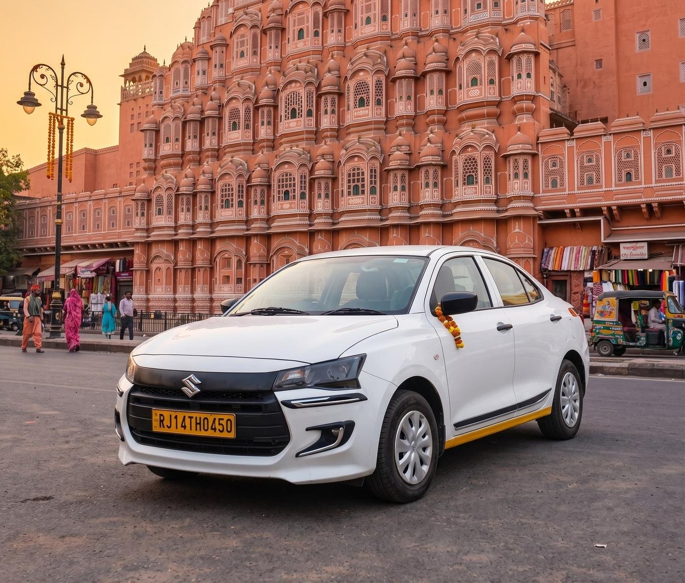 White Maruti Dzire sedan parked outside Hawa Mahal in Jaipur
